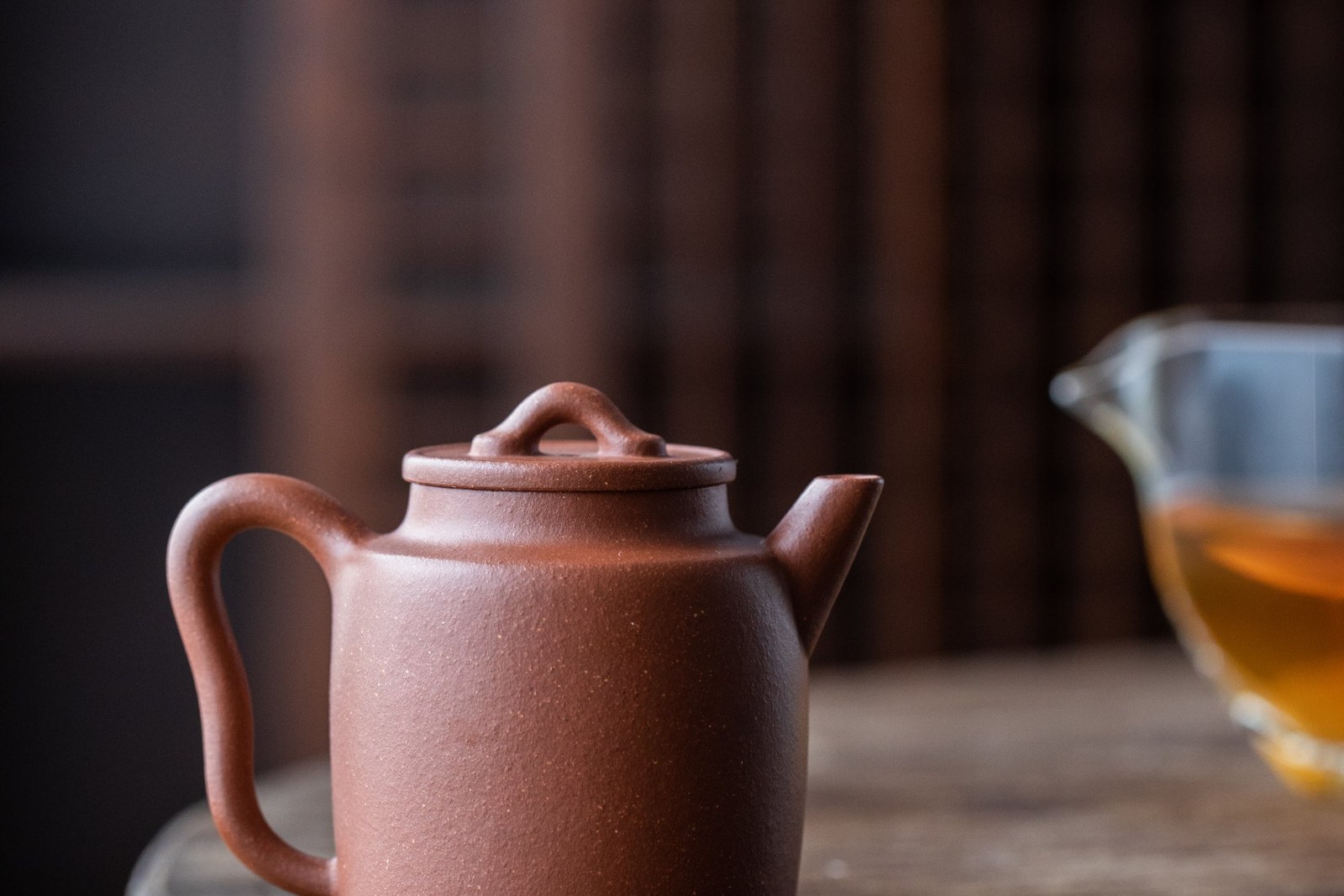 A Dark Ceramic Teapot On A Wooden Table